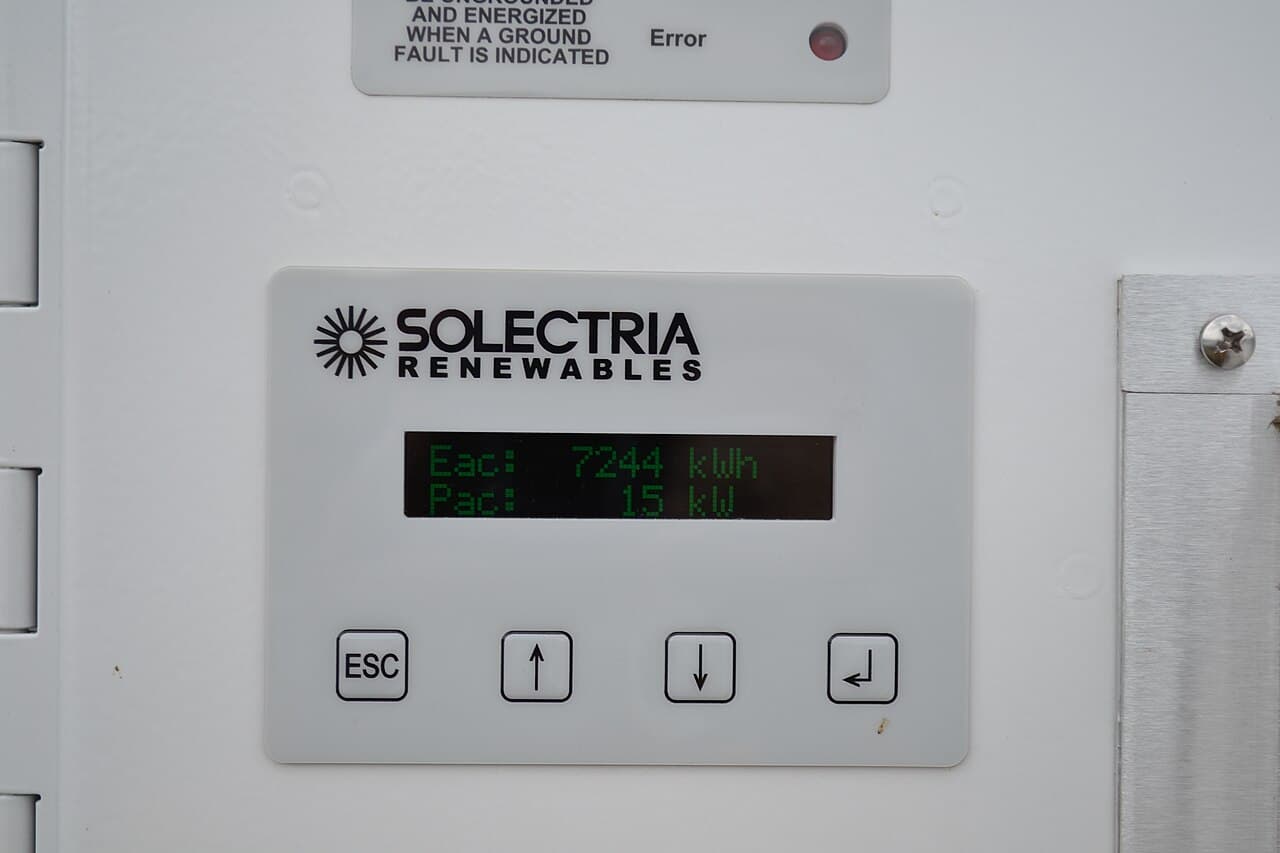 Photograph of a solar inverter display showing generated energy and instantaneous power; illustrative installation in Vermont